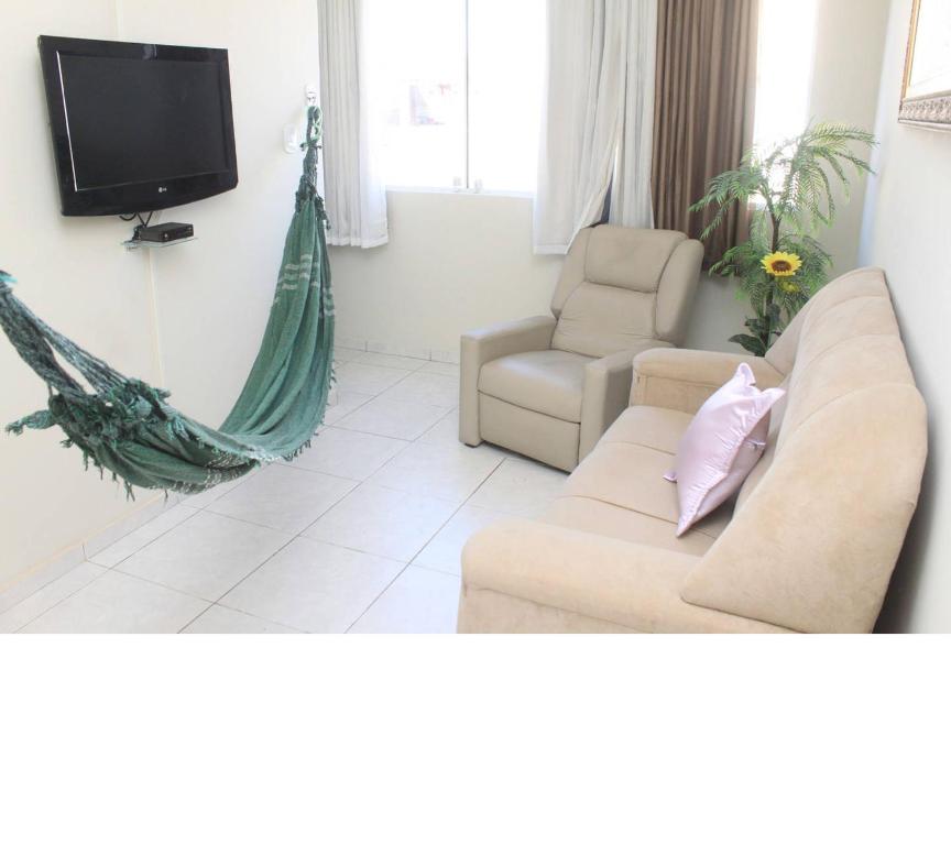 保罗阿方索城Excelente apartamento centro Paulo Afonso的带沙发、电视和吊床的客厅