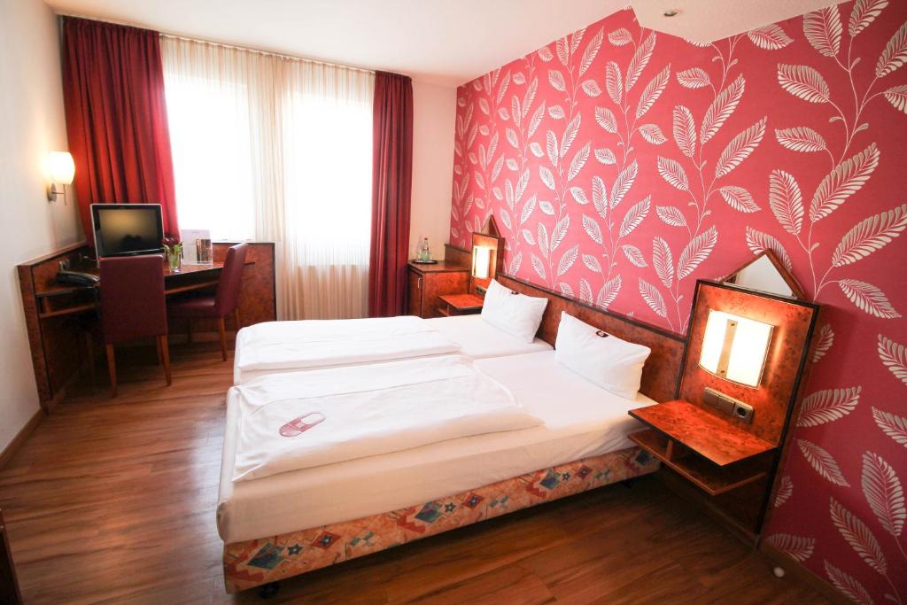 美因河畔法兰克福Hotel Miramar am Römer的酒店客房配有两张床和一张书桌