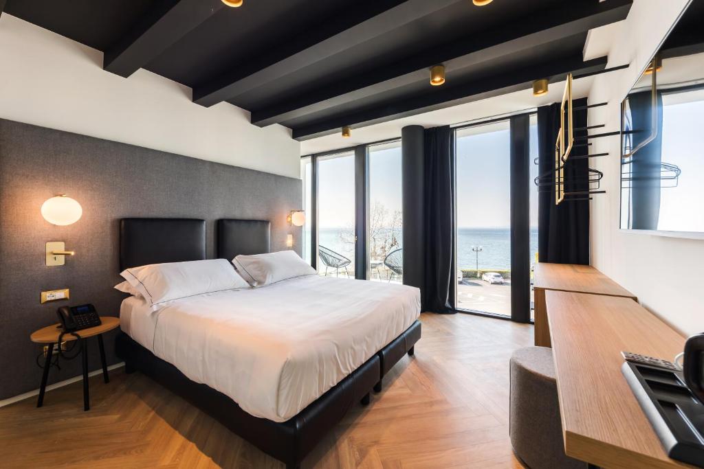 巴多利诺MaisonMe Boutique Hotel的一间卧室设有一张大床,享有海景