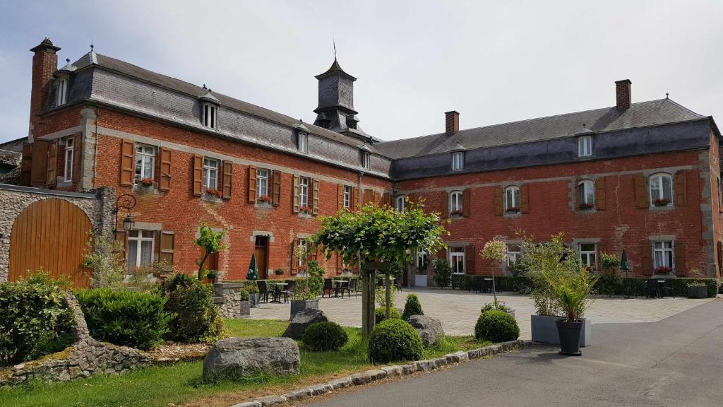 LiessiesLOGIS - Château de la Motte - Hôtel & Restaurant的一座带庭院的大型红砖建筑