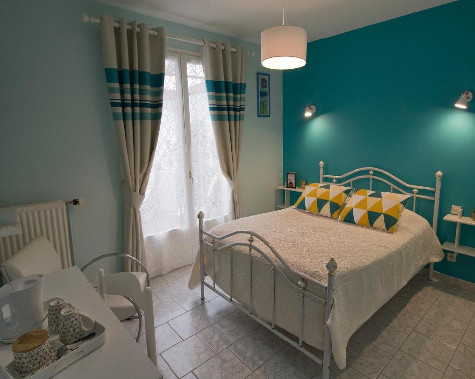 Nuisement-sur-CooleLes Rendzines的一间卧室设有一张床和蓝色的墙壁
