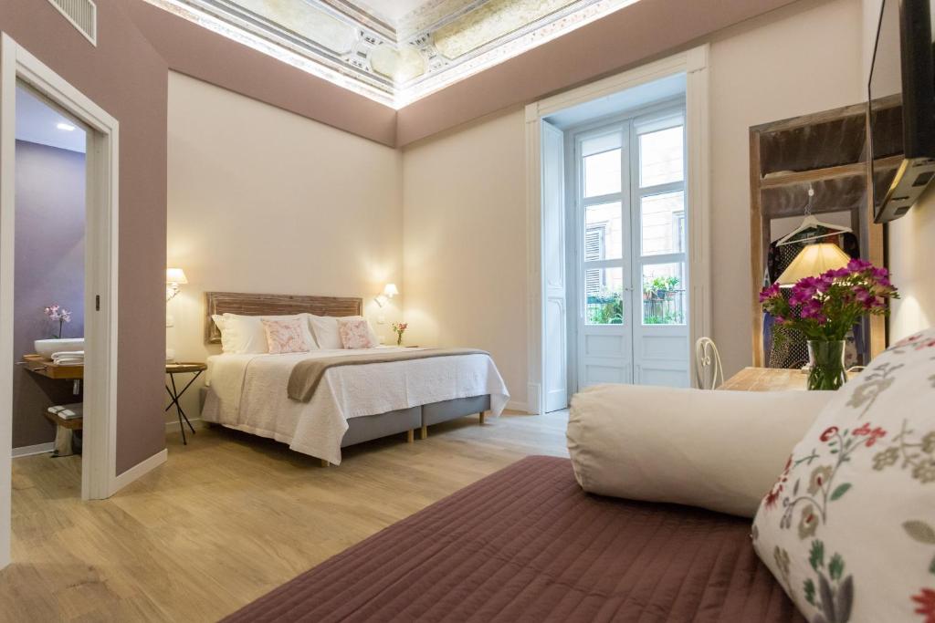 巴勒莫Bellaroto Suite & SPA的一间卧室设有一张床和一个大窗户