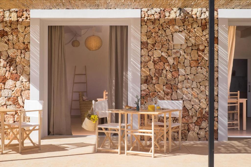 休达德亚Agroturismo Ses Talaies的一个带桌椅和石墙的庭院