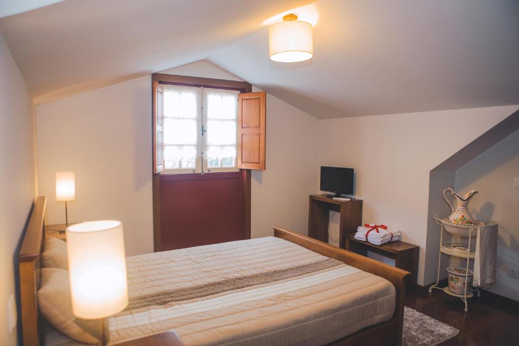 布罗Casa da Obrinha的一间卧室配有一张带两个灯和一扇窗户的床
