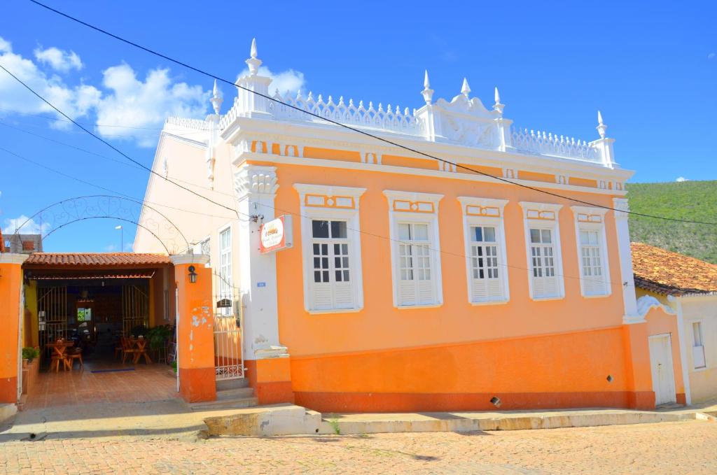 帕尔梅拉斯Hotel e Pousada O Casarão的一座橙色的建筑,街上有白色的窗户