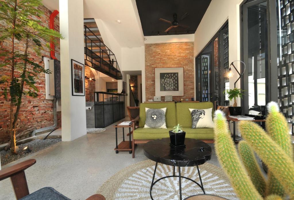 马六甲内斯特之家民宿的客厅配有绿色沙发和桌子