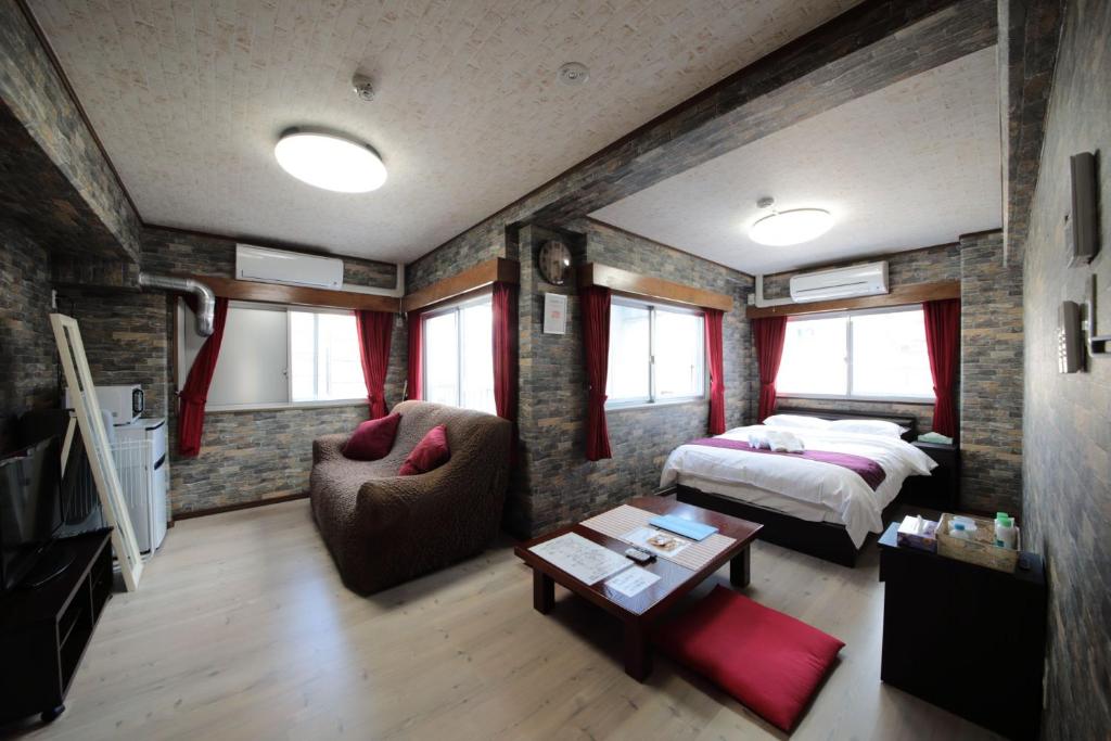 广岛La Foret Fujimi的一间卧室配有一张床、一张沙发和一张桌子