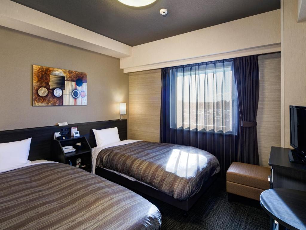 仙台仙台东区丽亚特经济型酒店的酒店客房设有两张床和电视。