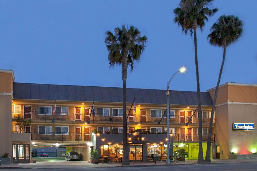 洛杉矶卡尔沃尔市旅者酒店的一座楼前有棕榈树的酒店