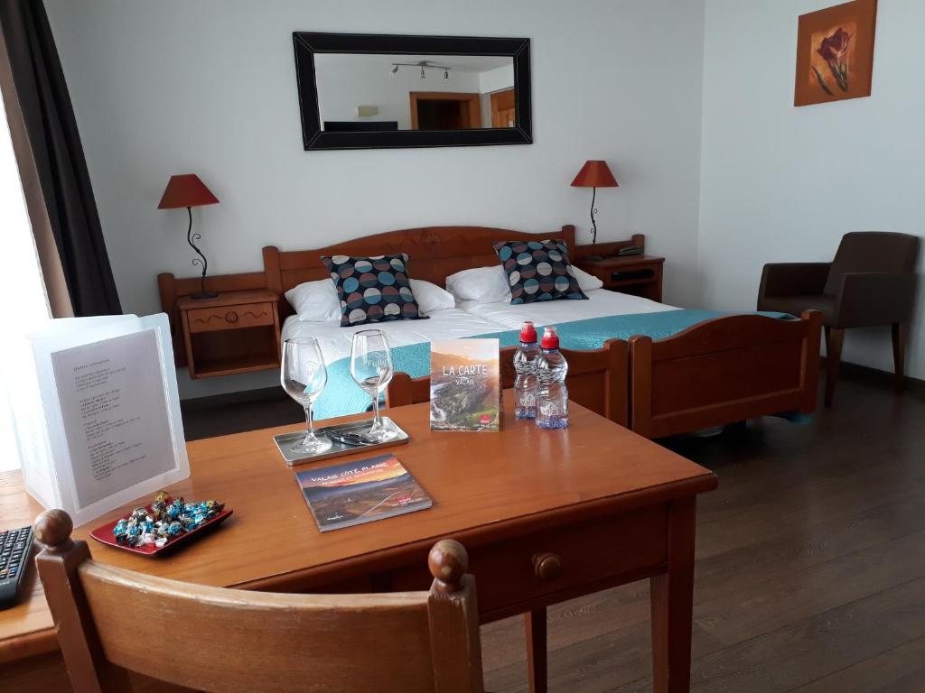 Fully福里酒店的客房设有一张床和一张带桌子的木桌。