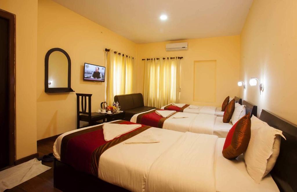 加德满都梦幻城酒店的酒店客房,设有两张床和镜子