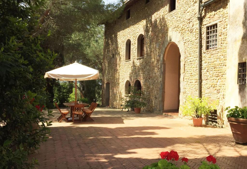 蒙泰卢波菲奥伦蒂诺Malmantile的一个带桌子和遮阳伞的庭院