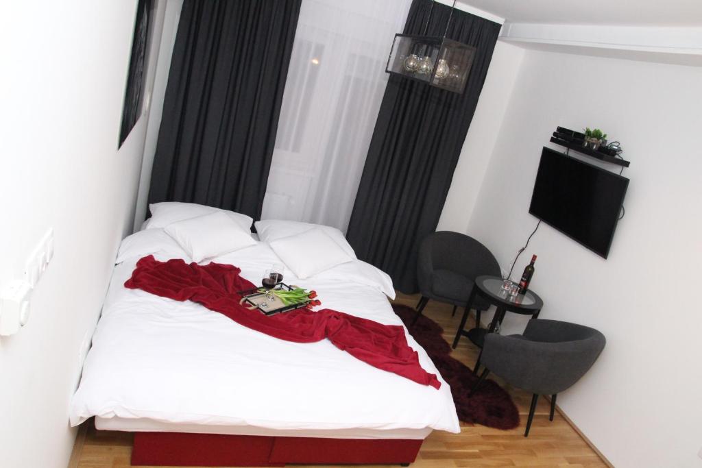 奥西耶克Top Center的一间卧室配有一张床铺,床上铺有红色毯子