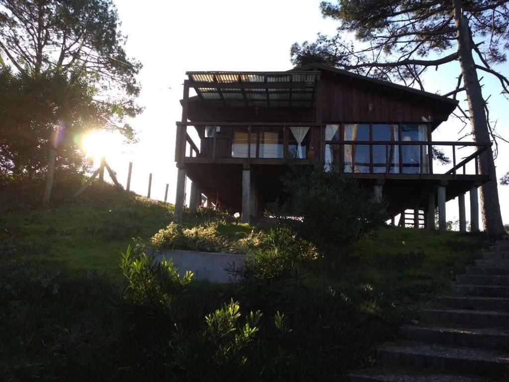 萨利纳斯Cabaña en la playa. ventanales y terraza al mar的山顶上的房子,有楼梯