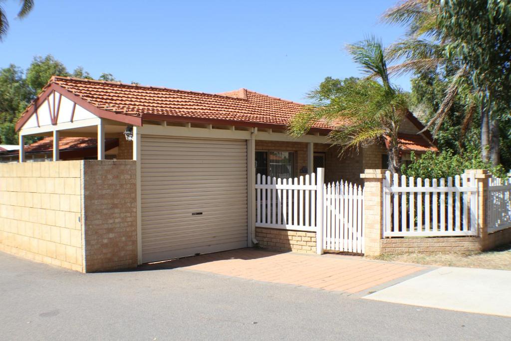 杰拉尔顿Geraldton Luxury Retreat 2 with free Streaming的一座带白色围栏和车库的房子
