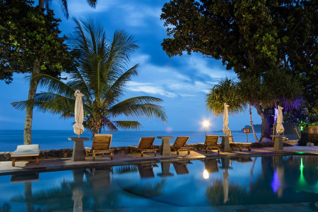 塞莱马德加庞多克派塔亚巴利恩酒店的游泳池配有椅子,晚上则享有海景