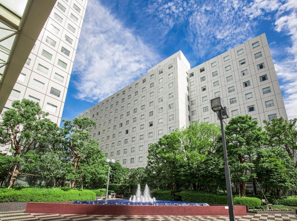 东京东京新大谷旅馆的两座大型白色建筑,前面有一个喷泉