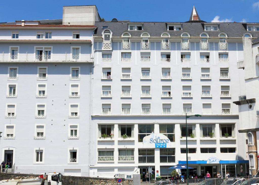 卢尔德菈桑斯酒店的一座白色的大建筑,上面有标志