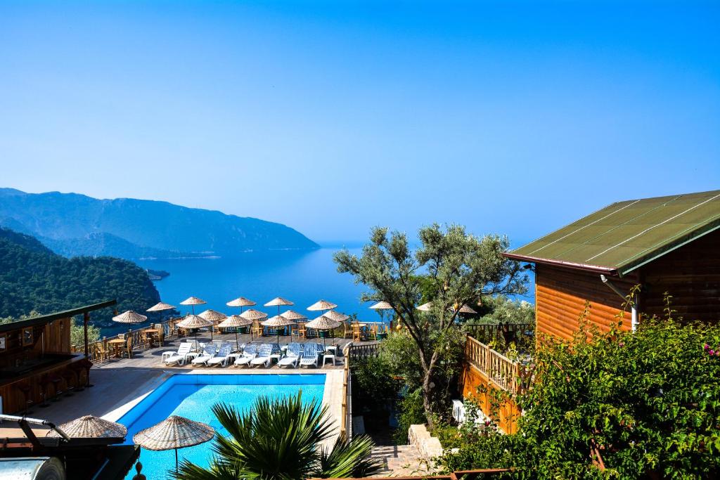 法拉尔雅卡巴克埃姆斯酒店的一个带遮阳伞和椅子的游泳池的度假酒店