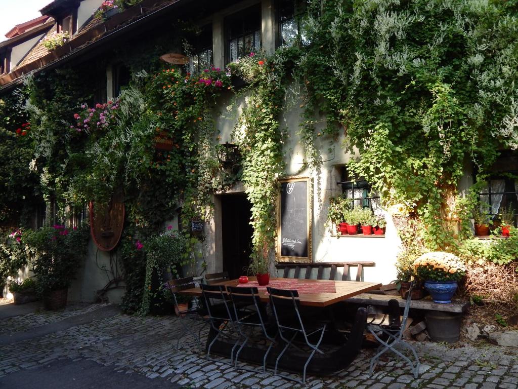罗滕堡艾尔弗拉恩基斯克葡萄酒馆酒店的鲜花盛开的建筑前的桌椅