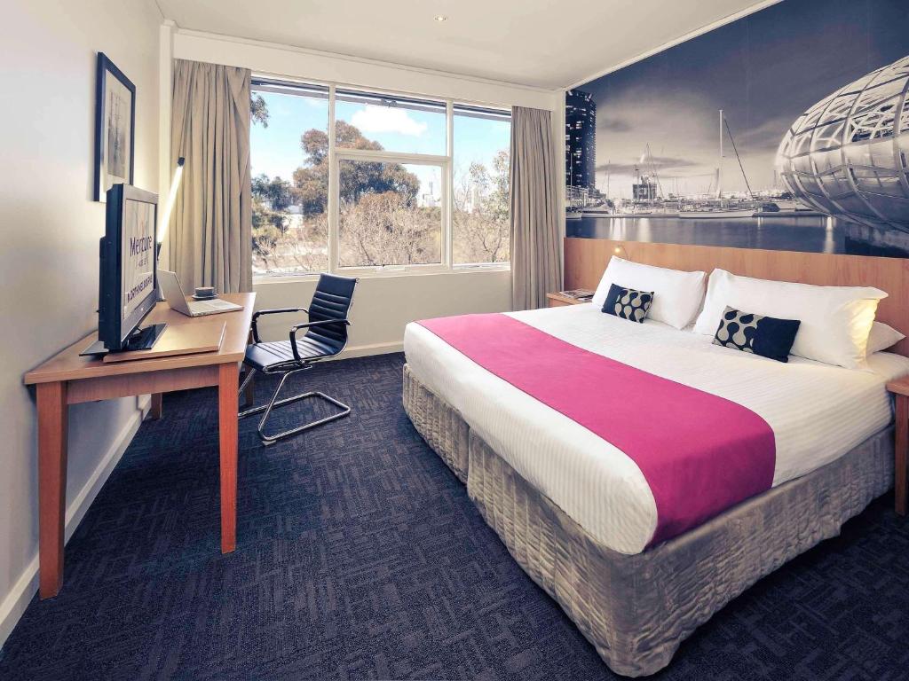 墨尔本北墨尔本美居酒店的酒店客房配有一张床、一张书桌和一台电视。