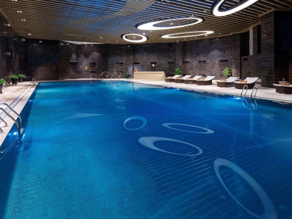 贵阳贵阳亨特索菲特酒店的大楼里的一个大型蓝色游泳池
