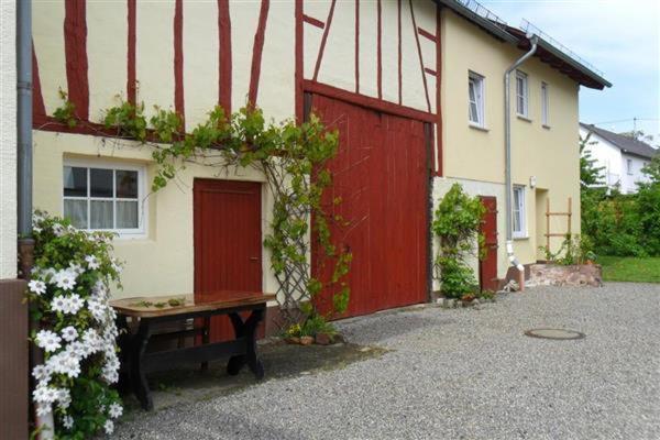 GondershausenZur alten Schreinerei的一座房子,前面有一扇红色的门和长凳