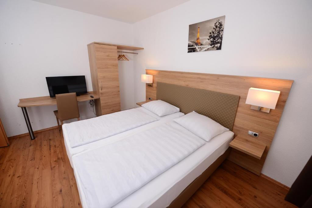 斯图加特林德斯图加特酒店的一间卧室配有一张床和一张书桌及电视