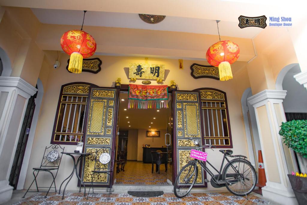普吉镇明寿精品屋酒店的停在有中国门的建筑前面的自行车