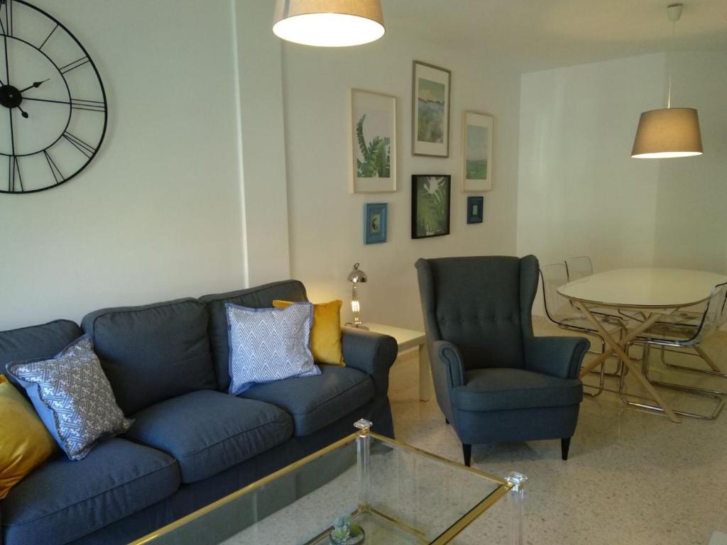 桑卢卡尔-德巴拉梅达Apartamento Estrella的客厅配有蓝色的沙发和两把椅子
