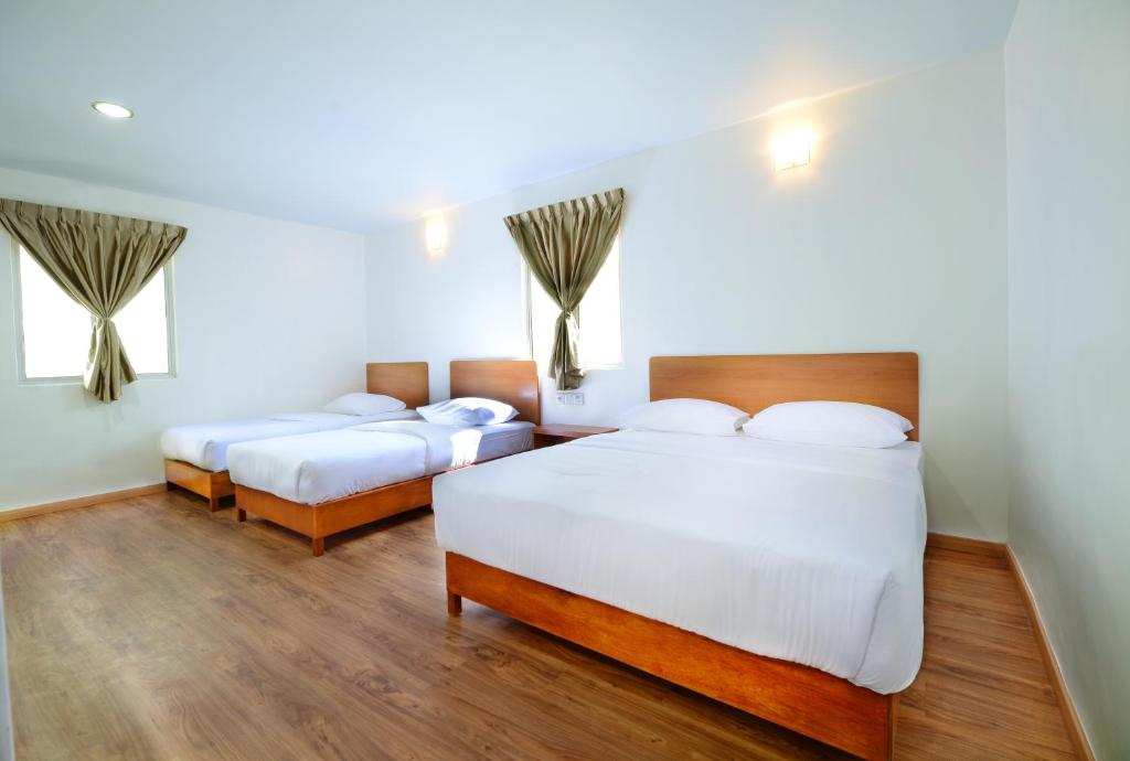 丰盛港MG酒店的铺有木地板的客房内的两张床