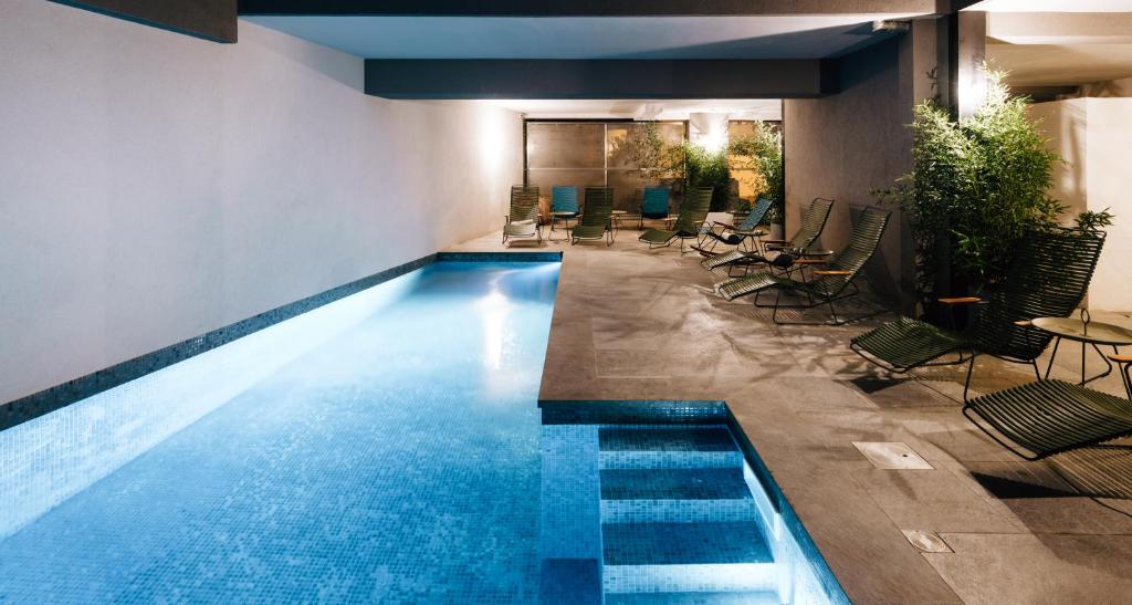 维琪奥港Citta di Lume Suites & Lofts的一座带桌椅的游泳池