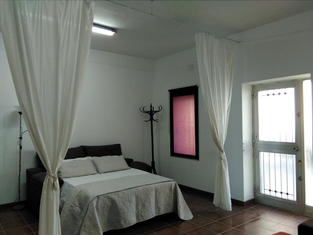 圣卡洛斯拉腊皮塔Ca la Valenta的卧室配有带白色窗帘的床和窗户。