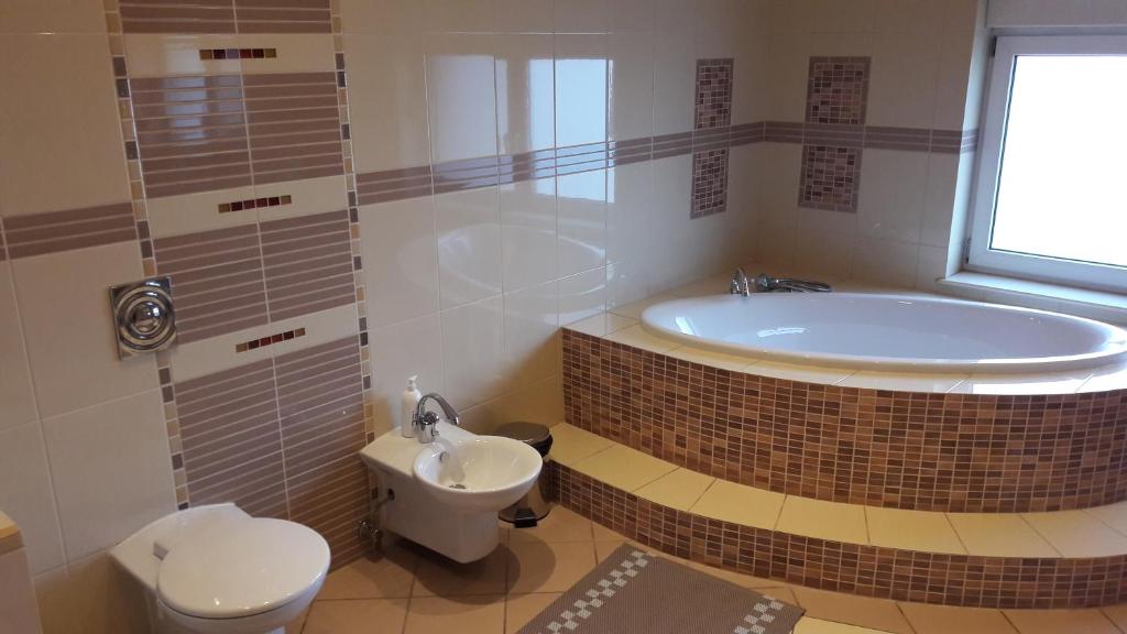 弗罗茨瓦夫帕拉迪索别墅旅馆的带浴缸、卫生间和盥洗盆的浴室