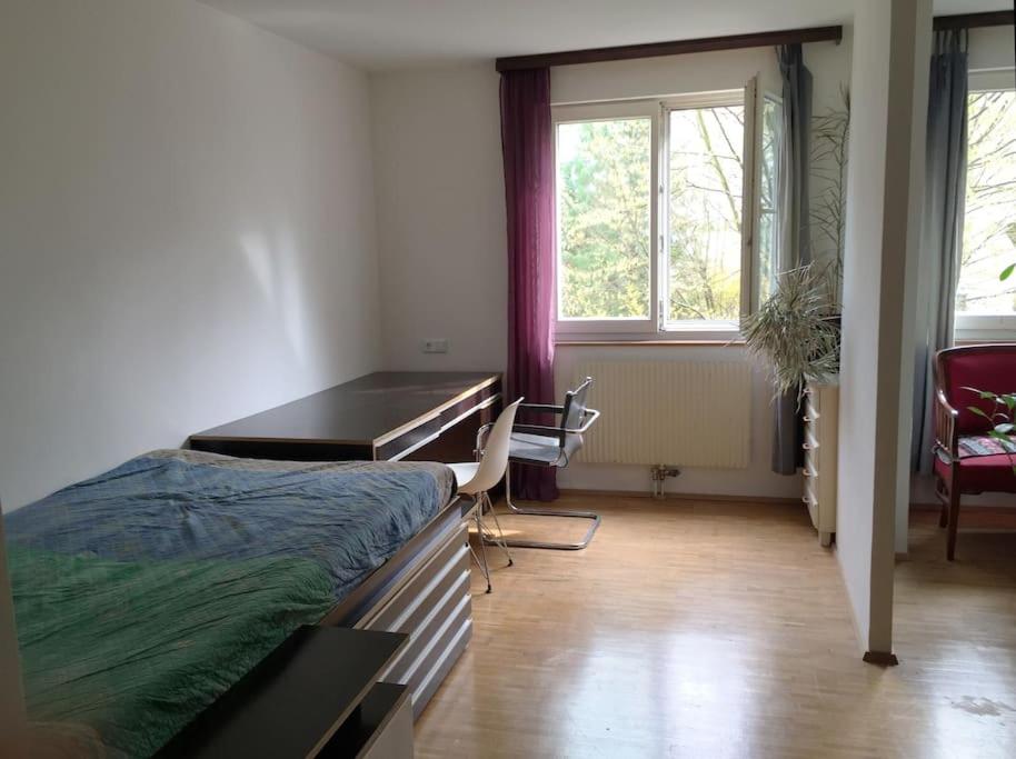 维也纳Room in maisonette with garden, parking place的一间卧室配有书桌、一张床和一张桌子