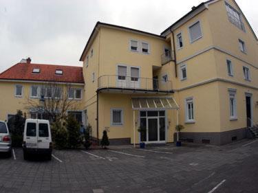 施派尔克尔法尔兹酒店的一座大型黄色建筑,有一辆白色的货车停在停车场