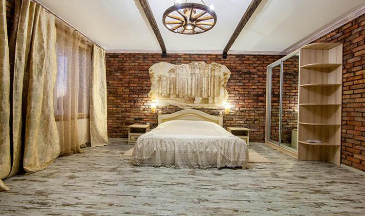 第聂伯罗韦莱斯酒店 的一间卧室设有一张床和砖墙