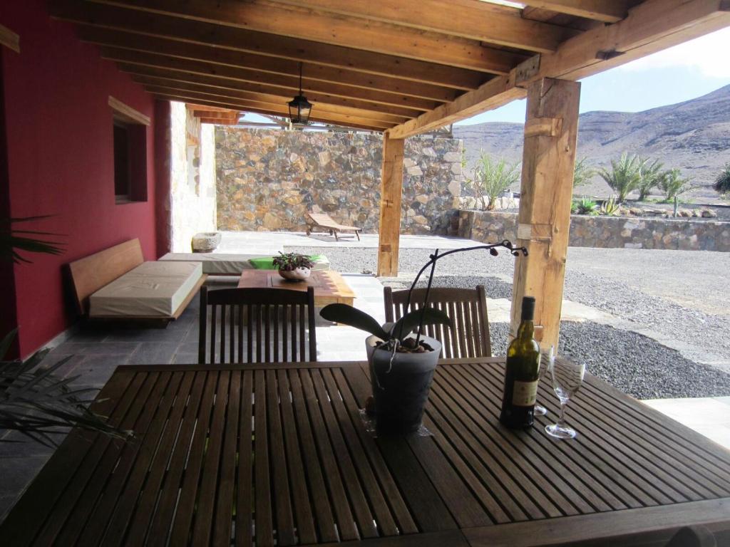 拉帕拉德Casa Perenquén的庭院里的木桌和一瓶葡萄酒