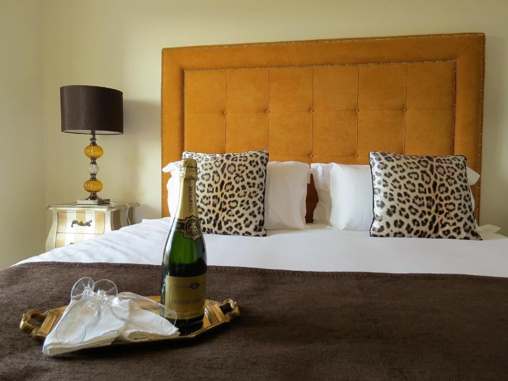 波尔蒂芒Sea Moments Apartments的一瓶香槟和床上的袋子