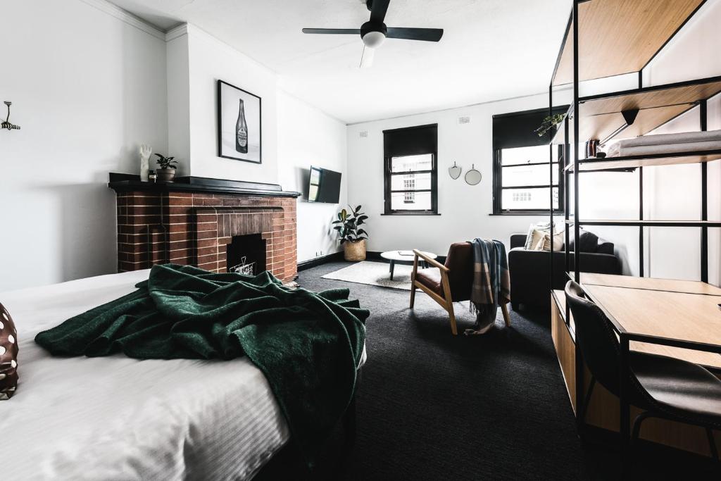 悉尼悉尼公园酒店 的一间卧室配有一张床、一个壁炉和一张桌子