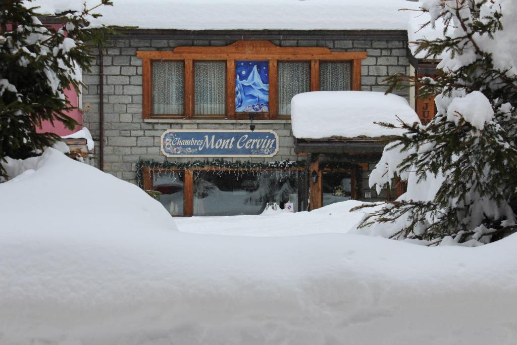 布勒伊-切尔维尼亚Chambres Mont Cervin的雪中标有标志的建筑物