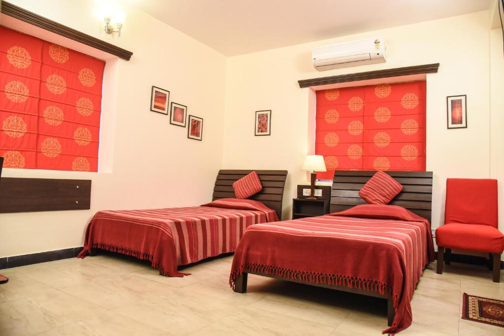 加尔各答Red Arrow Residency的一间设有两张床和红色墙壁的客房