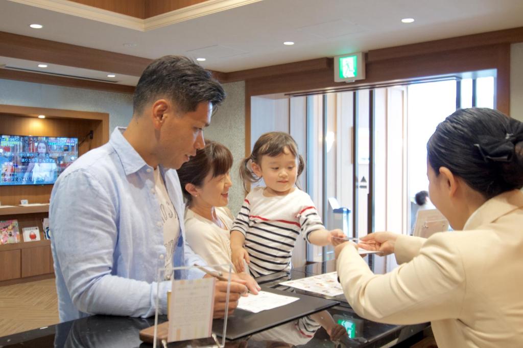 浦安日和舞滨酒店的一群人站在桌子旁,带着孩子
