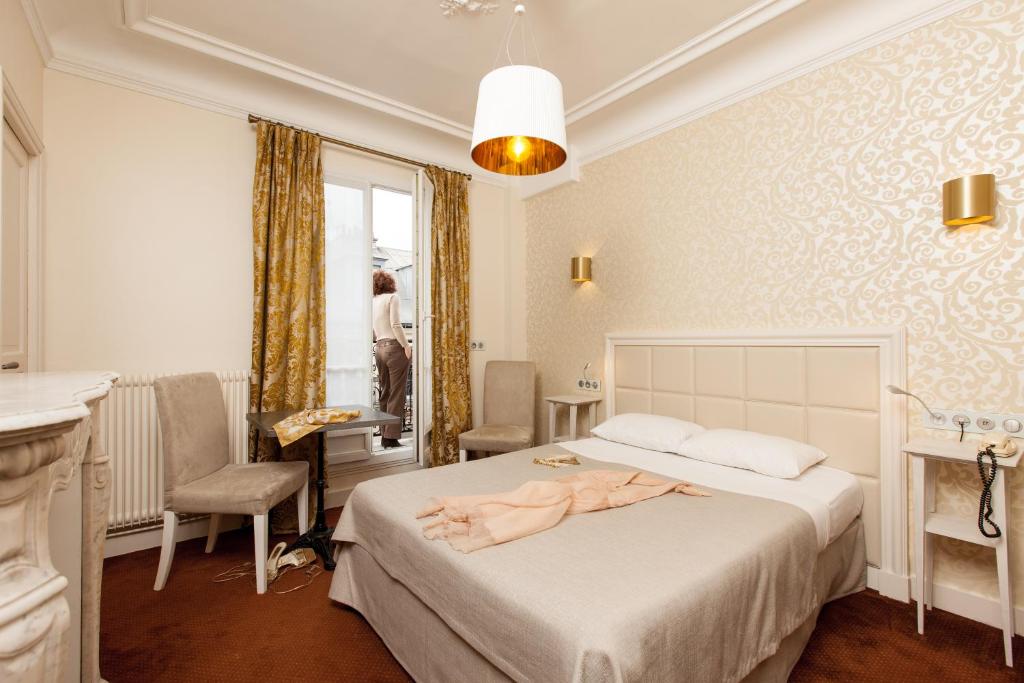 巴黎波拿巴特酒店的一间卧室配有一张床,床上有浴袍