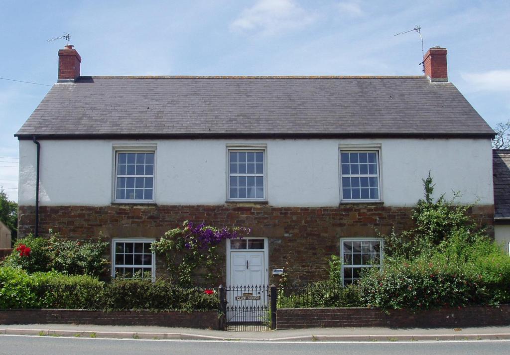 霍尔斯沃西Claw House的白色和红色砖砌的房子,有白色门