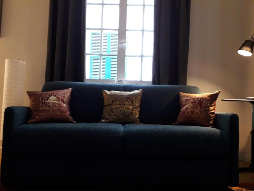 热那亚Cosy Little House的窗户前带枕头的蓝色沙发