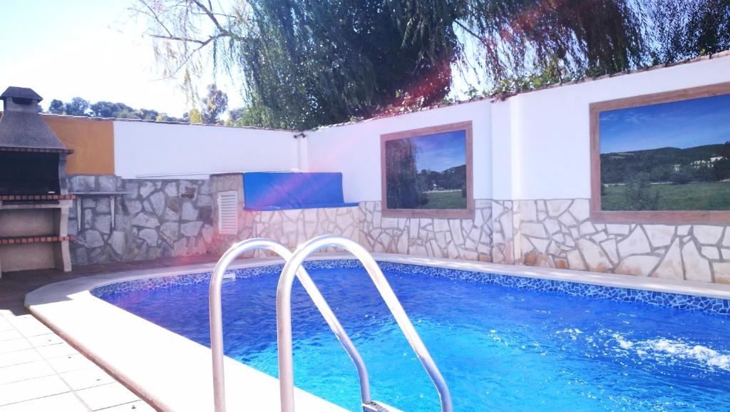 埃尔博斯克Casa La Vega的游泳池毗邻带游泳池的房屋