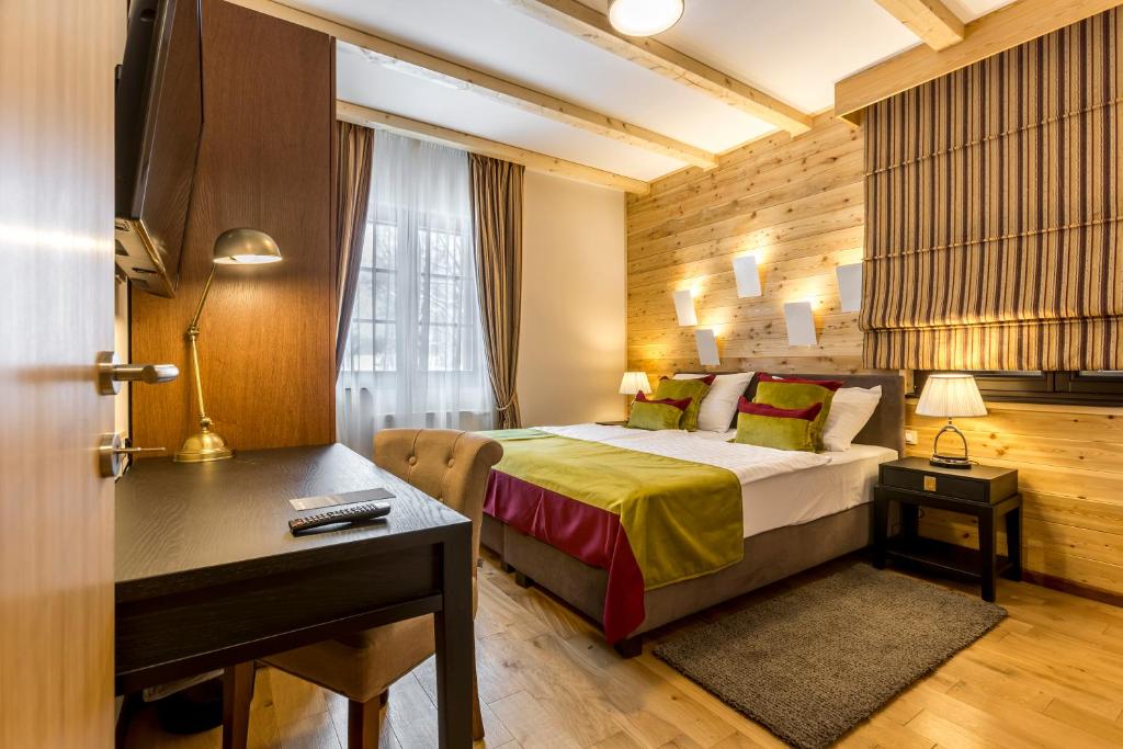 普利特维采湖Fenomen Plitvice Resort的酒店客房配有一张床、一张书桌和一张书桌。