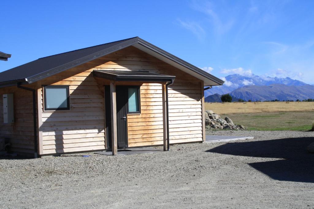 瓦纳卡Mt Barker的一座带门的小木结构建筑,背景是群山