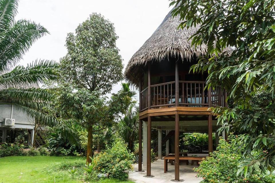 Ban Pa Lau帕拉优果园度假村的一座带甲板和草屋顶的建筑
